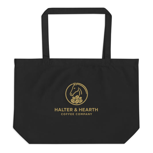 Halter & Hearth black tote bag with gold logo and a white background. 